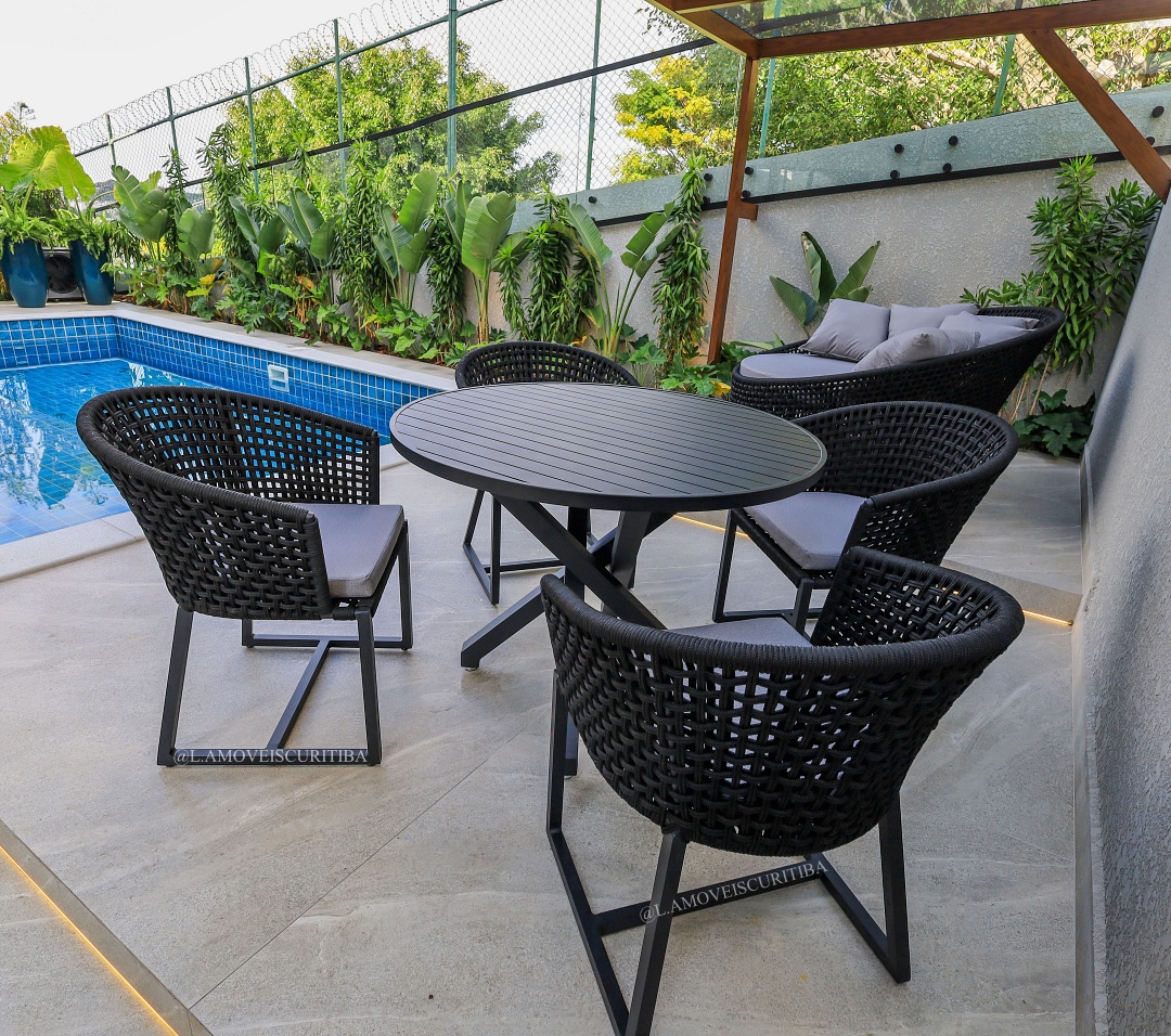 Conjunto de cadeiras Duna pretas com mesa redonda à beira da piscina